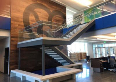 Commercial custom wall paneling with company branding and a staircase with custom benches